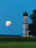 Partielle Mondfinsternis an der St Andreas Kapelle südlich von Weilheim, Bayern, Deutschland