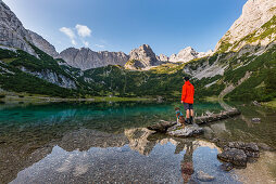 hiker with dog at scenic lake Seebensee in the Mieminger mountains, Tirol, Austria