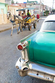 Oldtimer und Pferdekutsche auf einer der wenig befahrenen Straßen, Pferd, Stadt der Pferdekutschen, gut erhaltene koloniale Altstadt, historische Bausubstanz, Perle des Südens,  Familienreise nach Kuba, Auszeit, Elternzeit, Urlaub, Abenteuer, Cienfuegos, 