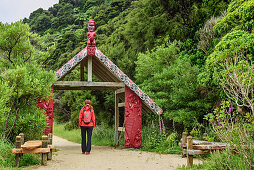 Woman hiking through gate of Abel Tasman Coastal Track, Abel Tasman Coastal Track, Great Walks, Abel Tasman National Park, Tasman, South island, New Zealand
