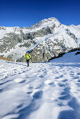 Frau steigt über Schnee zur Mueller Hut auf, Mount Sefton im Hintergrund, Hooker Valley, Mount Cook Nationalpark, UNESCO Welterbe Te Wahipounamu, Canterbury, Südinsel, Neuseeland