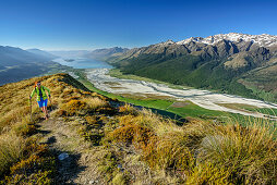 Woman hiking, Dart River Valley and Lake Wakatipu in background, Mount Alfred, Fiordland National Park, UNESCO Welterbe Te Wahipounamu, Queenstown-Lake District, Otago, South island, New Zealand