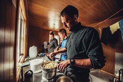 man cooking in a cabin, greenland, arctic.