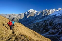 Man and woman hiking with Ortler in background, Stilfser Joch, Ortler group, South Tyrol, Italy