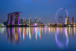 Beleuchtete Skyline von Singapur mit Marina Bay Sands, ArtScience Museum und Singapore Flyer, spiegelt sich in Marina Bay, Singapur