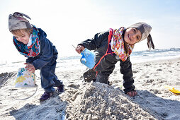 Kids playing at the beach in winter on Baltic Sea, Kellenhusen,  Schleswig Holstein, Germany