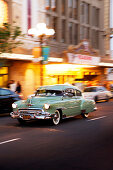 USA, California, San Diego, old cars speed off down the road near 5th Ave of the Gaslamp Quarter, a district of San Diego