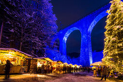 Verschneiter Weihnachtsmarkt unter einem Eisenbahn-Viadukt, illuminiert, Ravennaschlucht, Höllental bei Freiburg im Breisgau, Schwarzwald, Baden-Württemberg, Deutschland