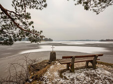 Aussichtsplatz mit Kreuz am Ufer des zugefrorenen Staffelsee, Seehausen, Oberbayern, Deutschland