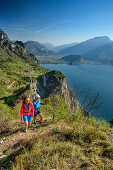 Mann und Frau wandern, Gardasee und Gardaseeberge im Hintergrund, Pregasina, Gardasee, Gardaseeberge, Trentino, Italien