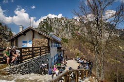 Many persons sitting at hut rifugio Nino Percin, rifugio Nino Percin, lake Garda, Garda Mountains, Trentino, Italy