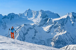 Woman backcountry-skiing ascending towards Piz Redival, Cima Presanella in background, Piz Redival, Val Strino, Ortler Group, Trentino, Italy