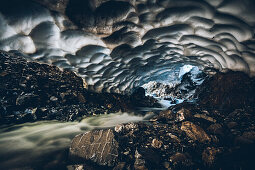 mountain river through old snow cave , E5, Alpenüberquerung, 1st stage Oberstdorf Sperrbachtobel to Kemptnerhütte, Allgäu, Bavaria, Alps, Germany