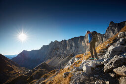 Hikers on the path to Lamsenspitze, Stallental valley and Lamsenjochhuette in the back,  Eastern Karwendel Range, Tyrol, Austria