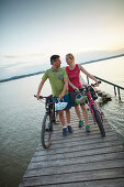 couple with Bikes on a jetty during bicycle tour, Ambach, bavaria, germany