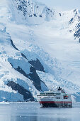 Die Fram (Hurtigruten ASA) fährt vor steilen, schneebedeckten und mit Gletschern versehenen Bergen, Neko Harbor, Graham Land, Antarktis