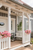 Front porch of custom home with white bench and flowerspots in sunlight, Korbach, Hesse, Germany, Europe