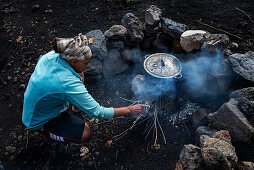 Landwirtschaft in den Lavafeldern der Insel Fogo, Mann an einer Kochstelle, Kap Verde