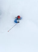 Skifahrer beim Tiefschneefahren verschwindet im Schneestaub, Hintertux, Tirol, Österreich