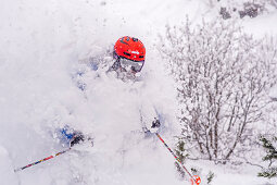 Skifahrer beim Tiefschneefahren verschwindet im Schneestaub, Hintertux, Tirol, Österreich