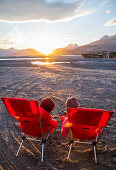Zwei Abenteurer genießen in ihren Camping-Stühlen die Abendstimmung, Island