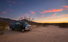 Van on the sand dunes of Kelso in the Mojave National Park at sunset