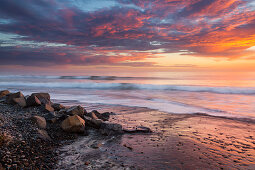 Sonnenuntergang am Strand an der Westküste Kaliforniens mit Wellen, USA\n