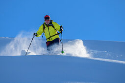 Mann auf Skitour fährt durch Pulverschnee ab, Regenfeldjoch, Kitzbüheler Alpen, Tirol, Österreich