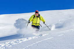 Man on ski tour starts through powder snow, Regenfeldjoch, Kitzbüheler Alpen, Tyrol, Austria