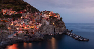 Bay in Cinque Terre with village Manarola in the evening with lights, Italy