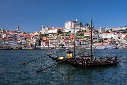 Traditionelle Schiffe auf dem Fluss Douro in Porto bei Tag mit Sonne, Portugal\n