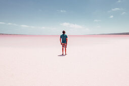 Männliche Person steht auf dem Pink Lake in Westaustralien, Australien, Ozeanien