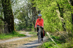 Frau fährt mit Rad auf Feldweg, Inn, Benediktradweg, Oberbayern, Bayern, Deutschland
