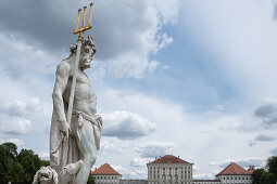 Blick auf das Schloss Nymphenburg, im Vordergrung eine Statue aus dem Garten der Götter, München, Bayern, Deutschland, Europa 