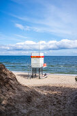 Rescue tower on the beach of Bansin with motor boat light swell cloudy sky, Usedom, Mecklenburg-Western Pomerania, Germany