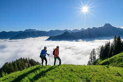 Man and woman hiking up over meadow, Nebelhorn and Höfats in the background, at Himmelschrofen, Allgäu Alps, Allgäu, Swabia, Bavaria, Germany