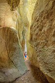 Woman hiking through canyon Gorges de Regalon, Gorges de Regalon, Luberon Natural Park, Vaucluse, Provence-Alpes-Cote d'Azur, France