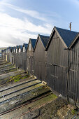 Schwarze Fischerboothütten im Hafen von Thorshavn, Färöer Inseln