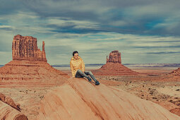 Frau sitzt vor dem Monument Valley, Arizona, Utah, USA, Nordamerika