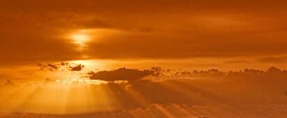 Orange leuchtender Himmel mit Sonnenstrahlen und Sonne, Abendsonne
