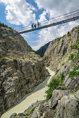 Drei Personen stehen auf Aletsch-Hängebrücke, UNESCO Weltnaturerbe Jungfrau-Aletsch, Berner Alpen, Schweiz