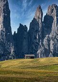 Einsame Hütte vor einer massiven Bergwand auf der Seiser Alm in Südtirol, Italien