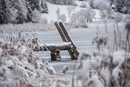 View over the frozen Geroldsee to snow-covered landscape, Krün, Bavaria, Germany.