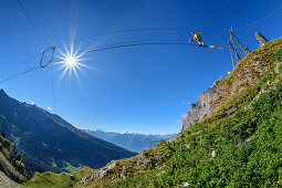 Woman on the Gemmi adventure via ferrata goes over rope bridge, Valais Alps in the background, Gemmi, Bernese Alps, Valais, Switzerland
