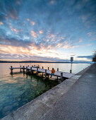 Sonnenaufgang an der Uferpromenade mit Badesteg am Nordufer des Starnberger Sees, Starnberg, Bayern, Deutschland.