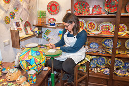 Eine Handwerkerin handbemalt traditionelle Keramik, Erice, Sizilien, Italien