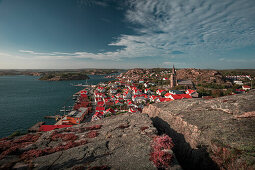 Küste und Dorf Fjällbacka vom Berg Vetteberget mit Felsspalte von oben bei Tag mit Sonne und blauem Himmel an der Westküste in Schweden 