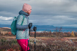 Woman hiking in Pieljekaise National Park in autumn in Lapland in Sweden