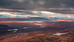 Mountain landscape with lakes and snow-covered peaks in Pieljekaise National Park in autumn in Lapland in Sweden