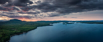 Forest and lakeshore at Lake Siljan from above in sunset with clouds in Dalarna, Sweden